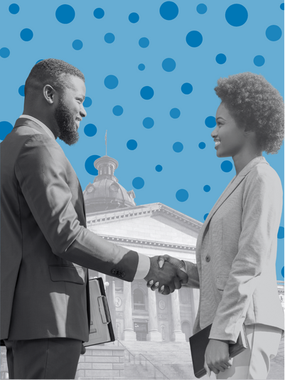 A black and white image of two dark skin people in suits shaking hands and standing in front of a government building.