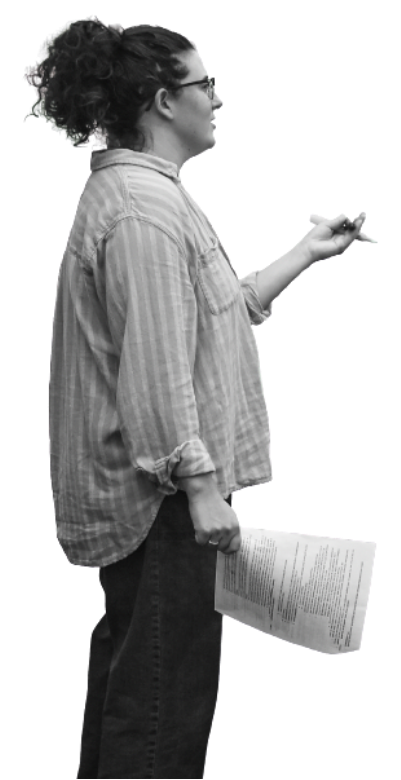 A black and white image of a young light skin woman standing with a piece of paper in one hand and gesturing with a pen with her other hand.